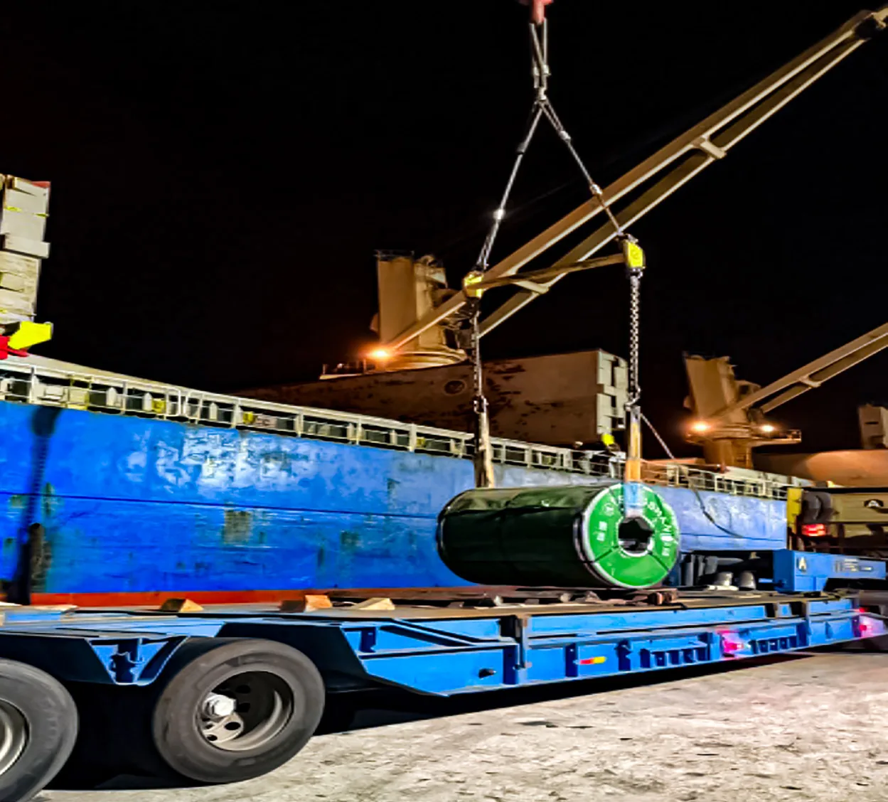 Heavy out-of-gauge cargo being transferred at night